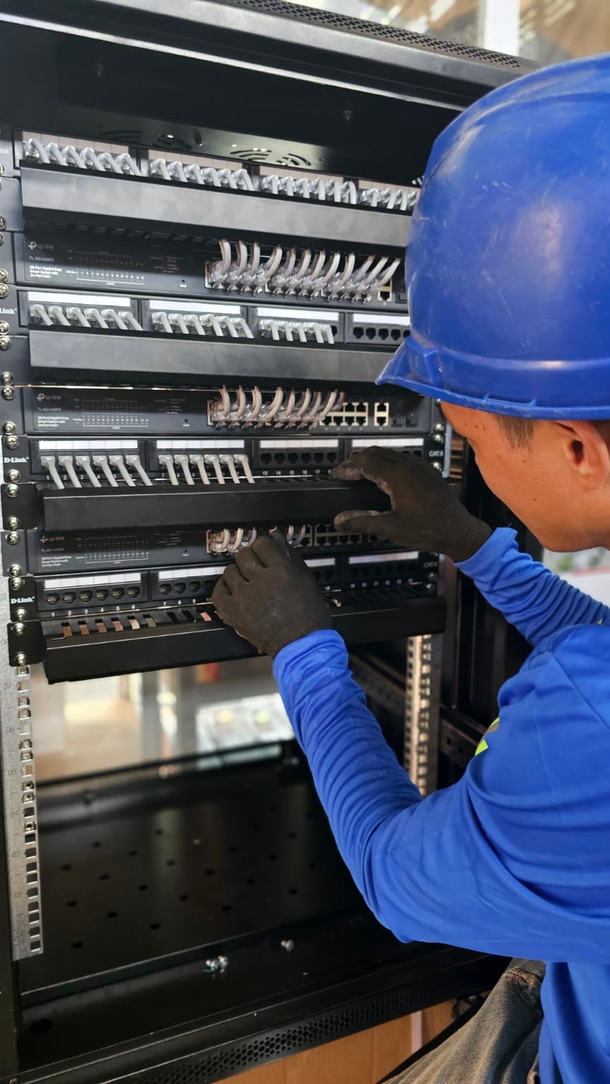 Technician installing cables into patch panels